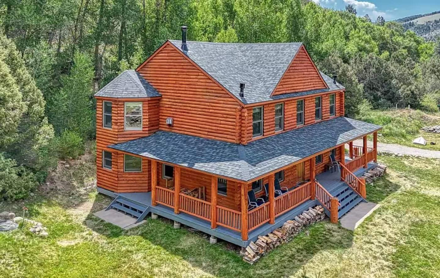 Aerial view of the log home with wraparound porch